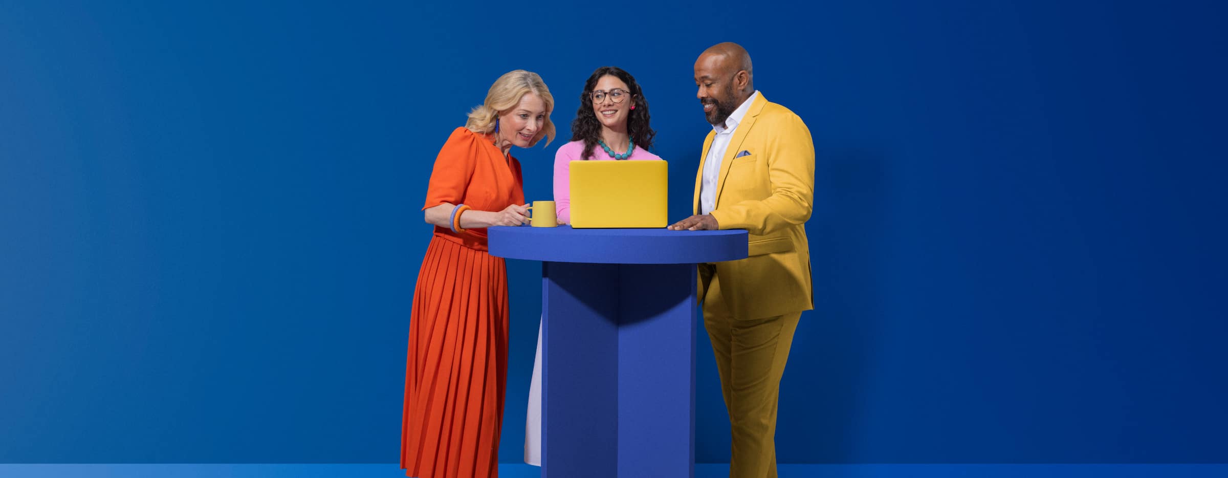 Three students share a laptop as they work through a business studies exercise online.